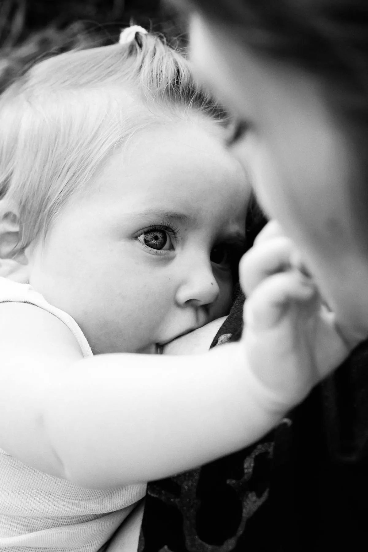Fotografía en blanco y negro de un niño abrazado a una persona adulta.
